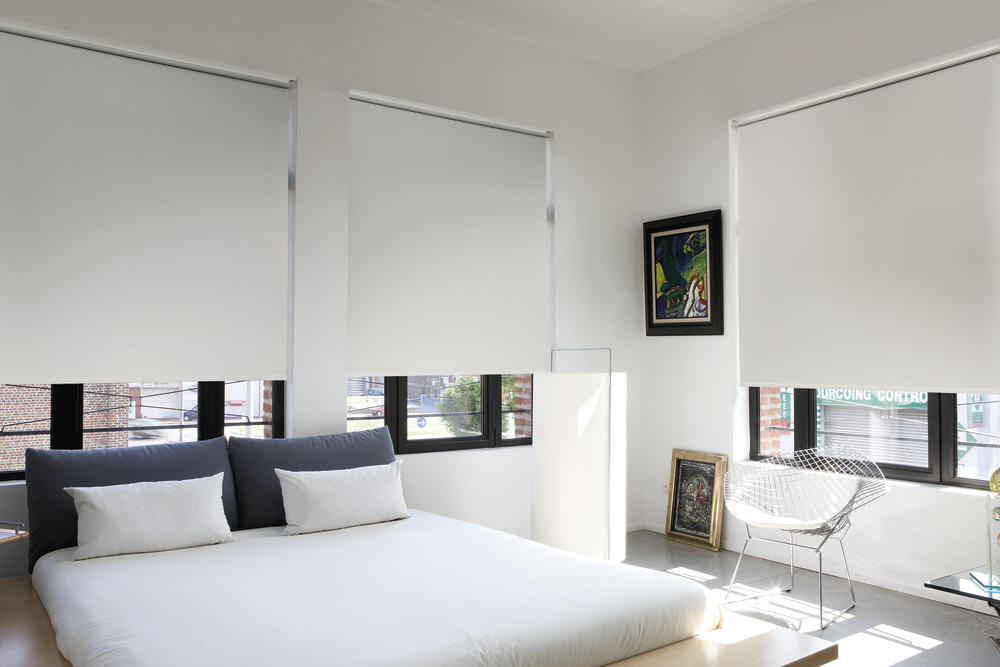 Persianas black out color blanco colocadas en gandes ventanales de dormitorio.