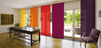 Persiana panel japonés de diferentes colores colocada en gran ventanal corredizo para adornar el interior de un espacio hogareño.