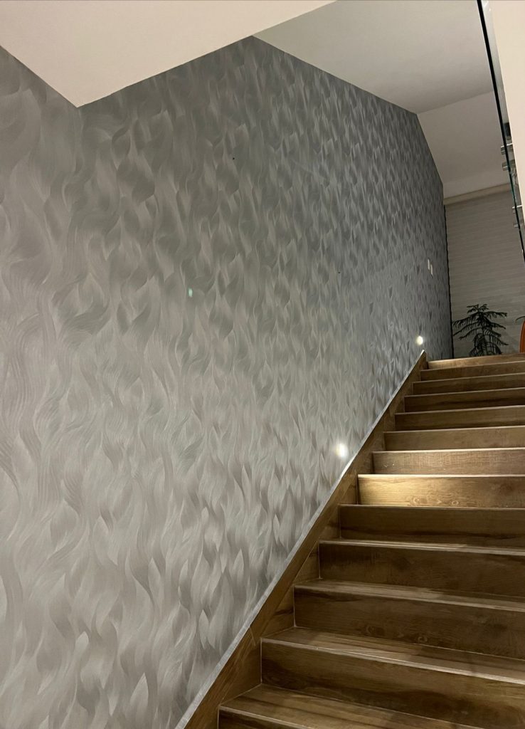 Papel tapiz color gris colocado en pasillo de escaleras.