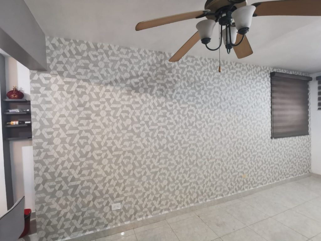 Papel tapiz de formas geometricas triangulares de color gris, colocado en pared de departamento.