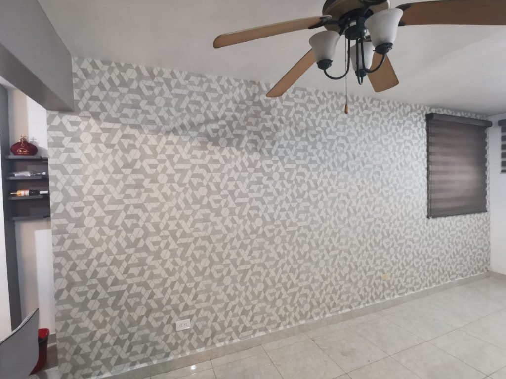 Papel tapiz de formas geometricas triangulares de color gris, colocado en una sola pared de casa.